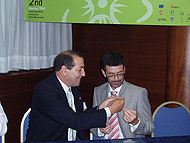 Foto 61.3 Nicolás Díaz Chico pone el pin del ICIC al Consejero de Sanidad del Cabildo de Lanzarote, Joaquín Carballo. 
